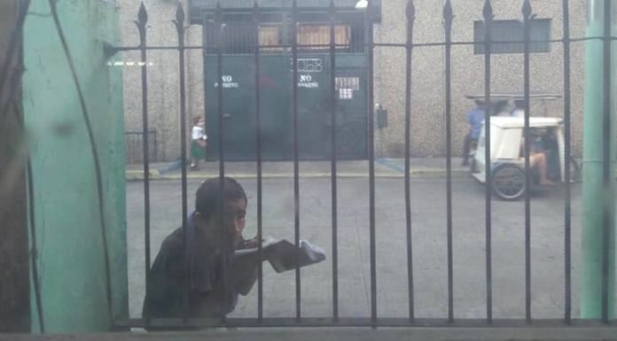 Anciano se asoma a una sala de clases para aprender desde la calle